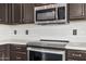A modern kitchen with dark cabinets, stainless steel appliances, and white countertops at 924 E Baylor Ln, Gilbert, AZ 85296