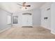 Bright living room featuring neutral carpet, ceiling fan, and double-door entryway at 924 E Baylor Ln, Gilbert, AZ 85296
