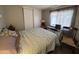 Cozy bedroom featuring a soft blue comforter, a wooden chair, and sliding closet doors at 9302 E Broadway Rd # 49, Mesa, AZ 85208