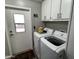 Laundry room with white washer and dryer, cabinets, and an exterior door at 9302 E Broadway Rd # 49, Mesa, AZ 85208