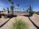 Outdoor view of a recreation area with pickleball courts and a lounge area with an umbrella at 9302 E Broadway Rd # 49, Mesa, AZ 85208