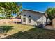 Well-maintained backyard features a grassy area, mature tree and covered patio for enjoying the outdoors at 9438 E Plana Ave, Mesa, AZ 85212