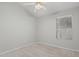 Monochromatic bedroom with window, fan and plush carpet at 9438 E Plana Ave, Mesa, AZ 85212