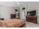 This bedroom features a dresser, TV and a decorative shelving unit at 9438 E Plana Ave, Mesa, AZ 85212