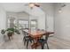 Bright dining room with tile floors, modern lighting, and a large wooden dining table at 9438 E Plana Ave, Mesa, AZ 85212