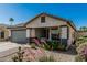 Charming single-story home features a desert landscaped front yard and a two-car garage at 9438 E Plana Ave, Mesa, AZ 85212