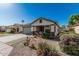 Charming single-story home features a desert landscaped front yard and a two-car garage at 9438 E Plana Ave, Mesa, AZ 85212