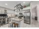 The well-lit kitchen features stainless appliances, a pot rack, and center island with barstool seating at 9438 E Plana Ave, Mesa, AZ 85212