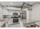 Contemporary kitchen equipped with stainless steel appliances, granite countertops, and a pot rack at 9438 E Plana Ave, Mesa, AZ 85212