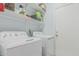 Bright laundry room with white appliances and ample shelving at 9438 E Plana Ave, Mesa, AZ 85212