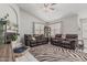 Bright living room with gray walls, a zebra rug, plants, and a large couch at 9438 E Plana Ave, Mesa, AZ 85212