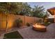Private backyard featuring a stone fire pit, pavers, shrubs, and uplighting at 10539 E Corbin Ave, Mesa, AZ 85212
