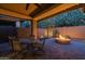 Backyard featuring a patio, outdoor dining area, a stone fire pit, and uplighting at 10539 E Corbin Ave, Mesa, AZ 85212