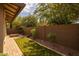 Backyard featuring a paver walkway, grassy area, uplighting, and trees at 10539 E Corbin Ave, Mesa, AZ 85212