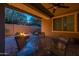 Backyard featuring a covered patio, outdoor dining area, and a stone fire pit at 10539 E Corbin Ave, Mesa, AZ 85212