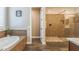Elegant bathroom features a soaking tub, step-in shower with designer tile, and stylish wood-look flooring at 10539 E Corbin Ave, Mesa, AZ 85212
