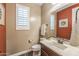 Well-lit powder room featuring a single sink vanity with a large mirror, plantation shutters, and modern fixtures at 10539 E Corbin Ave, Mesa, AZ 85212