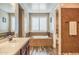 Stunning bathroom with soaking tub, dual sinks, dark wood cabinets, and step-in shower with custom tile at 10539 E Corbin Ave, Mesa, AZ 85212