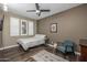 A cozy bedroom features a bed, rug, window, and teal armchair with white shuttered windows providing natural light at 10539 E Corbin Ave, Mesa, AZ 85212
