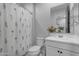 Bright bathroom featuring a shower with floral curtain, white vanity and toilet at 11357 E Unger Ave, Mesa, AZ 85212