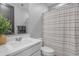 Clean bathroom showcasing white vanity and toilet with a neutral-striped shower curtain at 11357 E Unger Ave, Mesa, AZ 85212