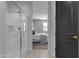 Modern bathroom with glass-enclosed shower leading to main bedroom with luxurious bedding at 11357 E Unger Ave, Mesa, AZ 85212