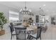 Bright dining area featuring a chandelier, decorative vase, and kitchen view at 11357 E Unger Ave, Mesa, AZ 85212