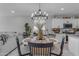 Bright dining area with an elegant chandelier, decorative centerpiece, and seamless flow to the kitchen at 11357 E Unger Ave, Mesa, AZ 85212