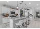 Bright and stylish kitchen with white cabinets, stainless steel appliances, large island and decorative pendant lighting at 11357 E Unger Ave, Mesa, AZ 85212