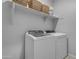 Bright laundry room showcasing front-load washer and dryer with overhead storage at 11357 E Unger Ave, Mesa, AZ 85212