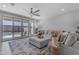 Bright living room with a large sectional sofa, and an outdoor view of the pool through sliding glass doors at 11357 E Unger Ave, Mesa, AZ 85212