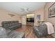 Inviting living room with wood floors, vaulted ceiling, and large TV for entertainment at 13349 W Boca Raton Rd, Surprise, AZ 85379