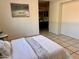 Bedroom with neutral walls and tile floors has a view of the ensuite bathroom; accent art on wall at 14216 N Saguaro Blvd # A, Fountain Hills, AZ 85268