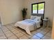 Bright bedroom features tile flooring, a queen bed, and natural light from a window with a view to the backyard at 14216 N Saguaro Blvd # A, Fountain Hills, AZ 85268