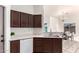 Inviting kitchen view, showcasing sink, dishwasher, dark wood cabinets, and a glimpse of dining area at 14216 N Saguaro Blvd # A, Fountain Hills, AZ 85268