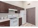 Functional kitchen with white appliances, dark brown cabinets, and tiled flooring, ready for culinary adventures at 14216 N Saguaro Blvd # A, Fountain Hills, AZ 85268