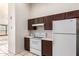 Well-lit kitchen features white appliances, sleek countertops, and dark wooden cabinetry at 14216 N Saguaro Blvd # A, Fountain Hills, AZ 85268