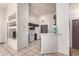 Modern kitchen featuring tiled floors, a breakfast bar, white appliances, and brown cabinetry at 14216 N Saguaro Blvd # A, Fountain Hills, AZ 85268