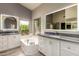 Modern bathroom features double vanities, a soaking tub, and a window overlooking lush greenery at 1590 W Desert Broom Dr, Chandler, AZ 85248