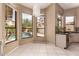 Bright breakfast nook boasts pool views from large windows, complemented by modern light fixture and tile floors at 1590 W Desert Broom Dr, Chandler, AZ 85248