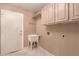 Bright laundry room with built in cabinetry, a utility sink, and a door to the outside at 1590 W Desert Broom Dr, Chandler, AZ 85248