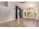 Open living space featuring wood-look floors, modern lighting, and an archway leading to another room at 1590 W Desert Broom Dr, Chandler, AZ 85248