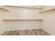 Spacious walk-in closet with light wood shelving and modern wood-look flooring at 1590 W Desert Broom Dr, Chandler, AZ 85248