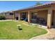 Charming backyard featuring a covered patio and green lawn with a bird bath at 15951 W Yavapai St, Goodyear, AZ 85338