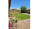 Large backyard has a grass lawn with flower beds surrounding a gravel area at 15951 W Yavapai St, Goodyear, AZ 85338