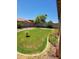 Large backyard features a grass lawn with mature trees and flower beds at 15951 W Yavapai St, Goodyear, AZ 85338