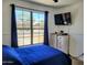 Cozy bedroom with a bright window, and a TV with modern neutral furnishings at 15951 W Yavapai St, Goodyear, AZ 85338