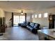 Spacious living room featuring tile floors, ceiling fan and sliding glass door to backyard at 15951 W Yavapai St, Goodyear, AZ 85338