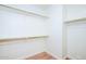 Spacious walk-in closet features shelving units, rod for hanging clothing and wood floor at 1642 E Palm Beach Dr, Chandler, AZ 85249