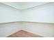 Spacious walk-in closet features shelving units, rod for hanging clothing and wood floor at 1642 E Palm Beach Dr, Chandler, AZ 85249